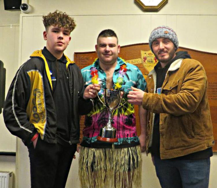 Llangwm skipper Gethin Thomas receives the new trophy from Johnny James sons Sion and Josh